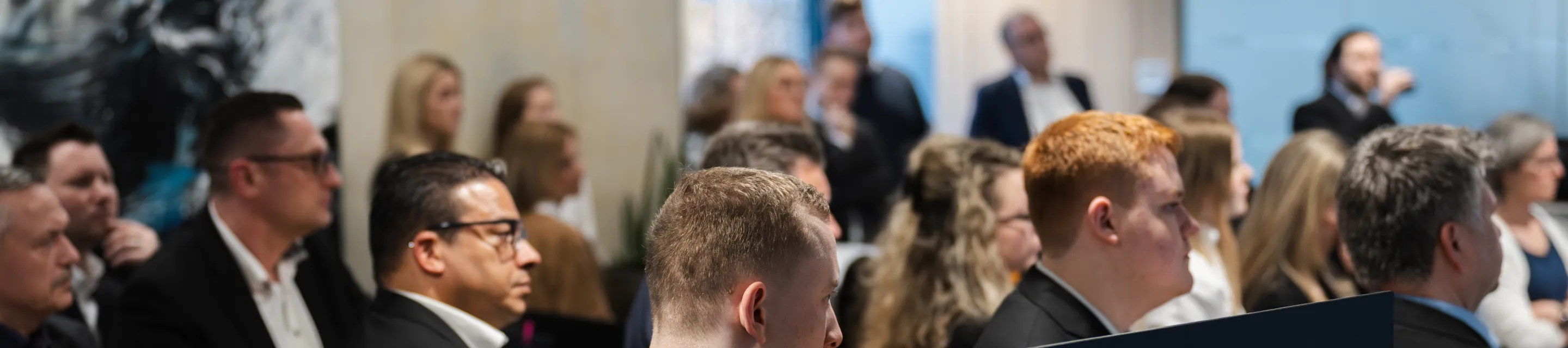 Kolleginnen und Kollegen hören beim Jahresauftakt in der Hauptstelle zu